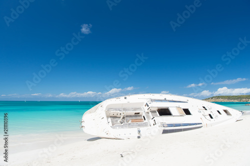 Ship or luxury white boat lay on sand beach, skyline background. After storm always return sun. Yacht on st.johns beach. Entertainment summer vacation yachting. Boat yacht landed on sand coast photo