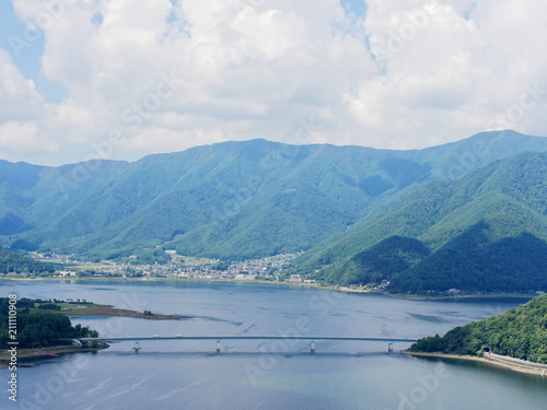 Scenery of Lake Kawaguchi, the biggest lake of Fuji five lakes, with an overwater bridge crossing the lake and mt Kurodake on the background, famous tourist destination in Japan