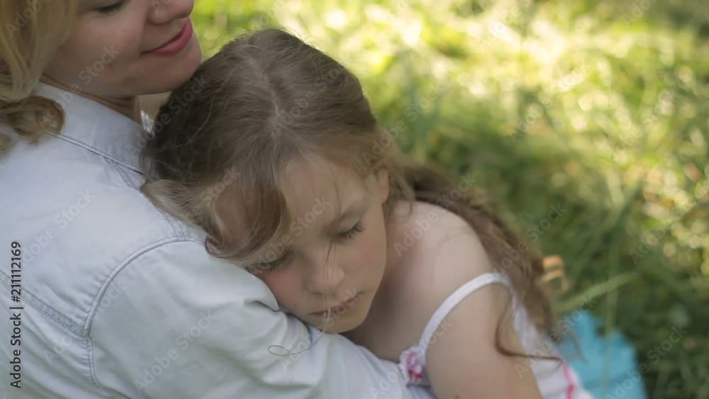 Lovely mom patting on hair her dozing child outside. Happy motherhood. Lovely mom patting on hair her dozing child outside. Happy motherhood.