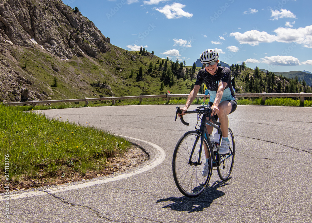 Fototapeta premium Woman Cyclist Climbing Dolomites Cycling Alta Badia Trentino Alto Adige Italy Sella Ronda Bike Day