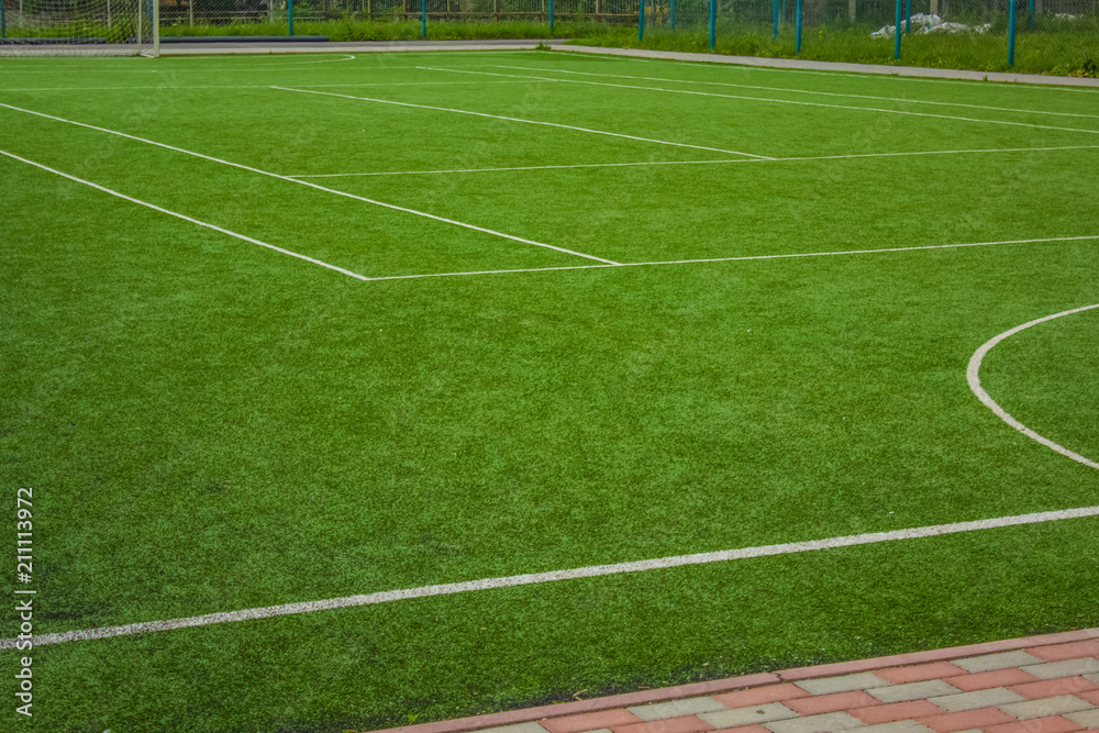 Obraz premium sport concept synthetic small football field green grass background texture and white marking lane with empty space for copy or text