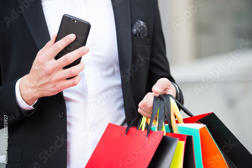 Shopping on cyber monday or black friday sale. New technology for business communication. Shopping bags and smartphone in hands of man. After day shopping. digital marketing for successful buy online