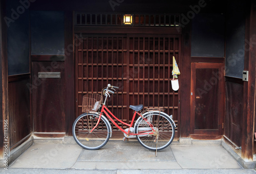 Red mama cheri bicycle in front of Japanese wooden sliding door photo