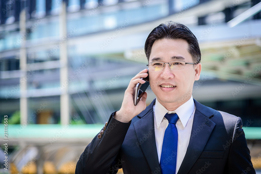 The asian businessman has working on mobile with happy. The asian businessman has working on mobile with happy.