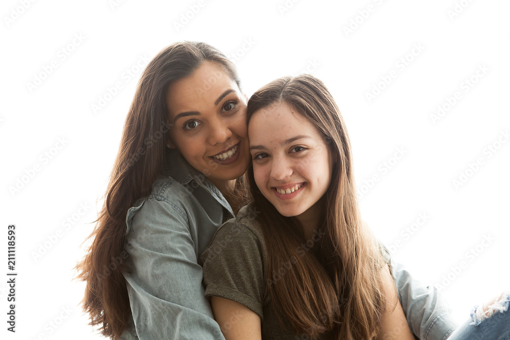 Portrait of two sisters next to a big bright window. Happy family Portrait of two sisters next to a big bright window. Happy family