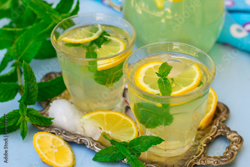 Sweet lemon beverage lemonade with mint and ice cubes photo