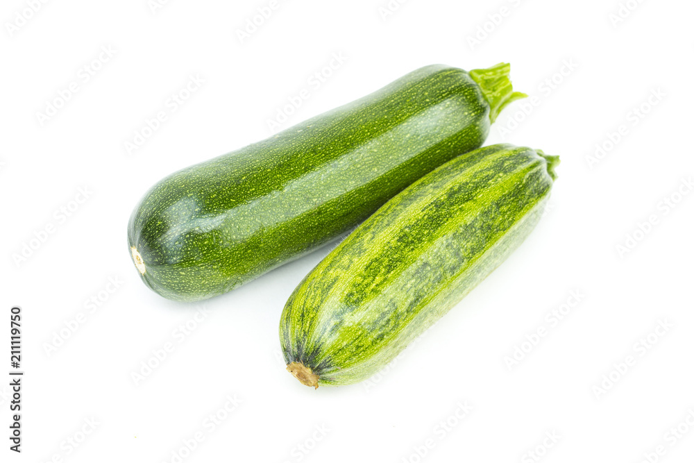 Two whole fresh green ripe zucchini or courgettes, object isolated on white background Two whole fresh green ripe zucchini or courgettes, object isolated on white background