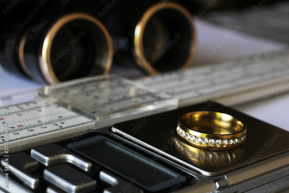 Gold ring with diamonds and a measuring instrument