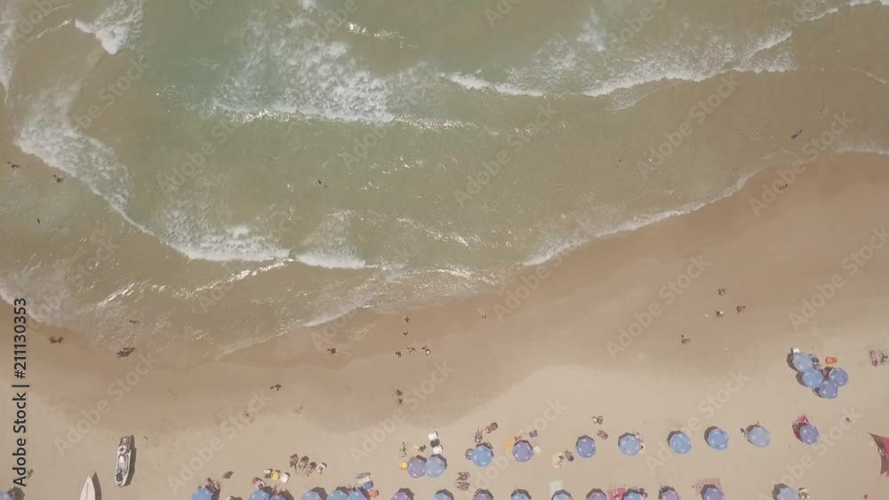 Beautiful sandy beach with people and colourful umbrellas - Top down aerial footage Beautiful sandy beach with people and colourful umbrellas - Top down aerial footage