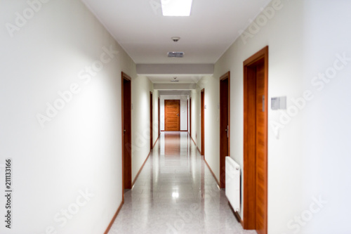 White hallway with brown doors