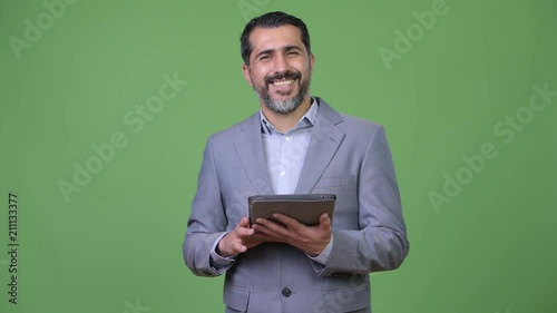 Handsome Persian bearded businessman using digital tablet