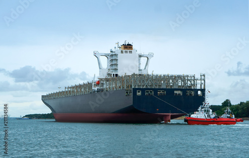 Cargo ship escorted by two guards. Empty container ship. Sea cargo ship.
