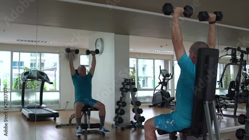 Man performs an exercise with dumbbells on an inclined bench athletic