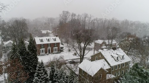 Aerial Drone flying above houses in Villanova, PA suburban Philadelphia area in heavy snow photo