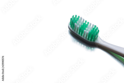 Green toothbrush on a gray background closeup