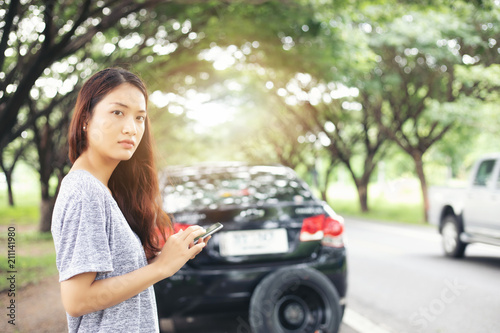 Asian woman using mobile phone while looking and Stressed man sitting after a car breakdown on street © tuiphotoengineer