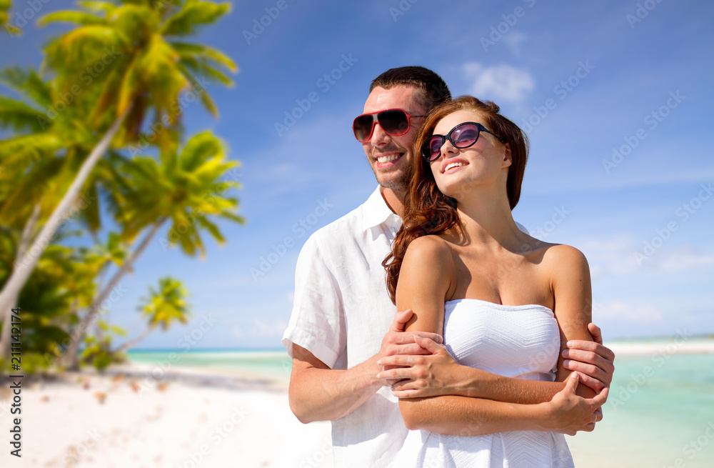 travel, tourism and summer vacation concept - happy smiling couple in sunglasses over tropical beach background in french polynesia travel, tourism and summer vacation concept - happy smiling couple in sunglasses over tropical beach background in french polynesia