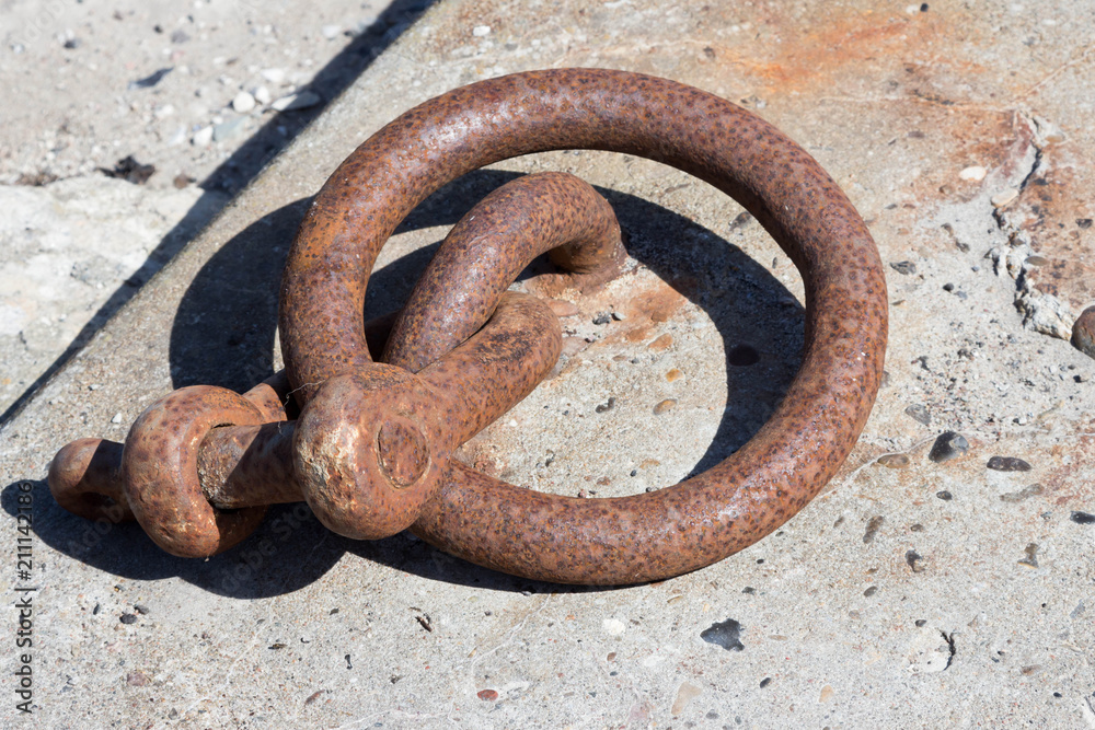 Rostiger Ring mit Schäkel zum Festmachen im Hafen Rostiger Ring mit Schäkel zum Festmachen im Hafen
