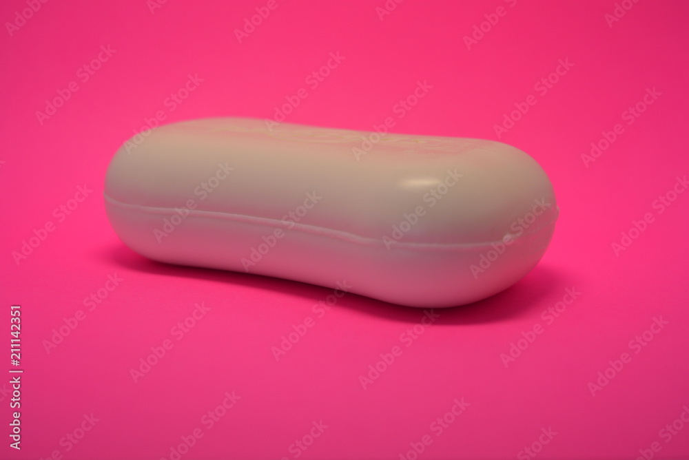 On a bright colorful pink paper background is located and placed a cosmetic antibacterial white soap for face and skin On a bright colorful pink paper background is located and placed a cosmetic antibacterial white soap for face and skin