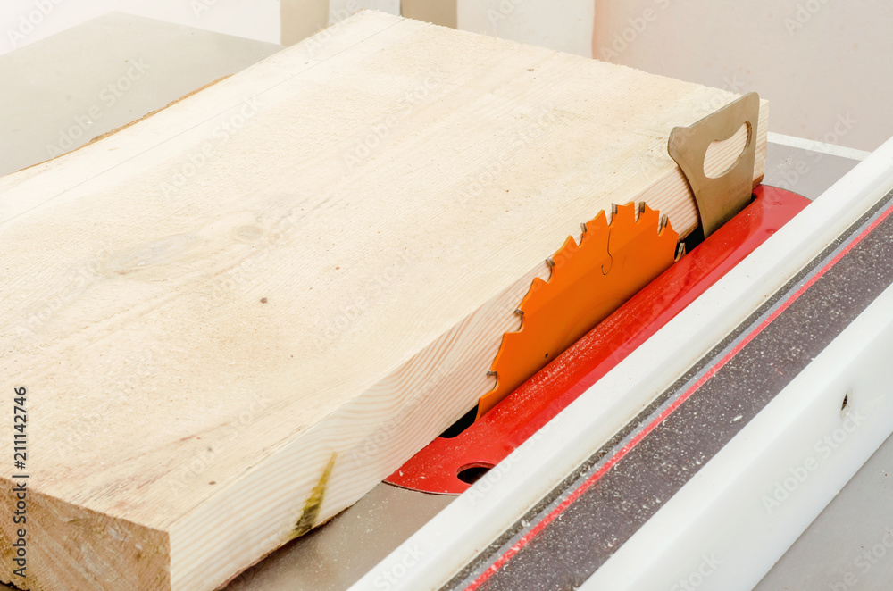 Cutting the board on a circular saw in a woodworking workshop Cutting the board on a circular saw in a woodworking workshop