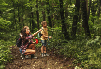 Mother and her little sons  hiking trough forest .Watching birds.