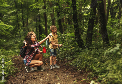 Mother and her little sons  hiking trough forest .Watching birds.