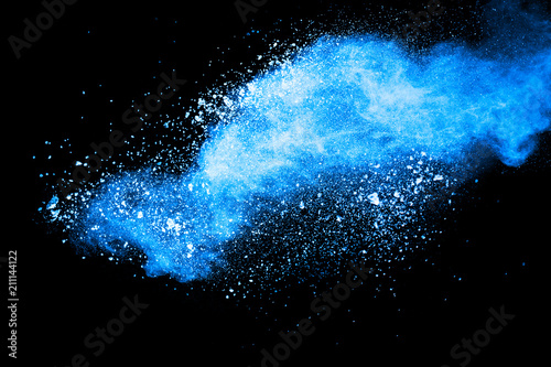 Abstract blue dust explosion on black background. Freeze motion of blue powder splash. Painted Holi in festival.