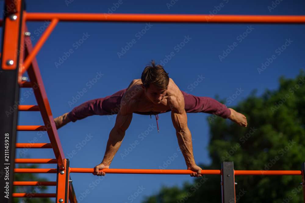 Fototapeta premium Muscular man making planche on the street. Street workout