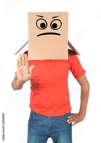 Young man gesturing with a cardboard box on his head with sad face isolated on white background