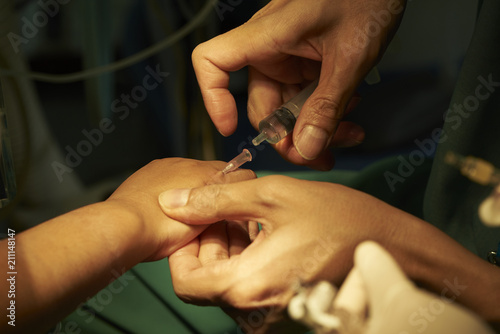 Anesthesiologist accessing a patient venous line