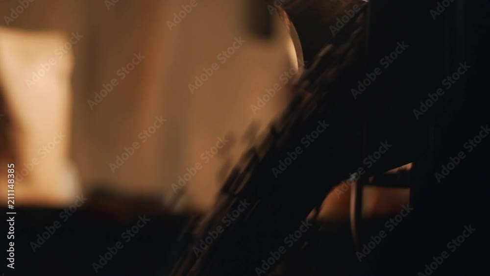 Cropped closeup view of barista man working with roaster machine, roasted arabica coffee beans falling from equipment, in slow motion