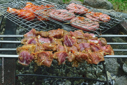 Marinated shashlik from pork preparing on a bonfire charcoal. Popular eastern dish can be called Shish kebab