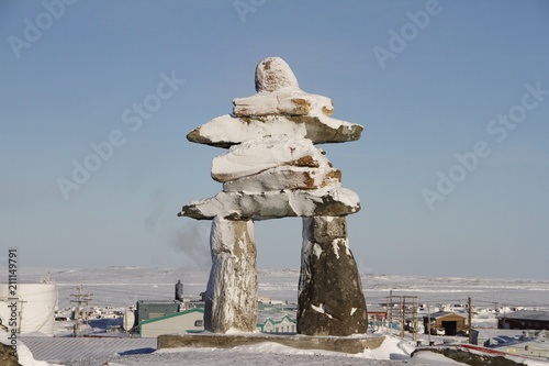 Inukshuk or Inuksuk landmark covered in snow found on a hill in the community of Rankin Inlet, Nunavut in February photo