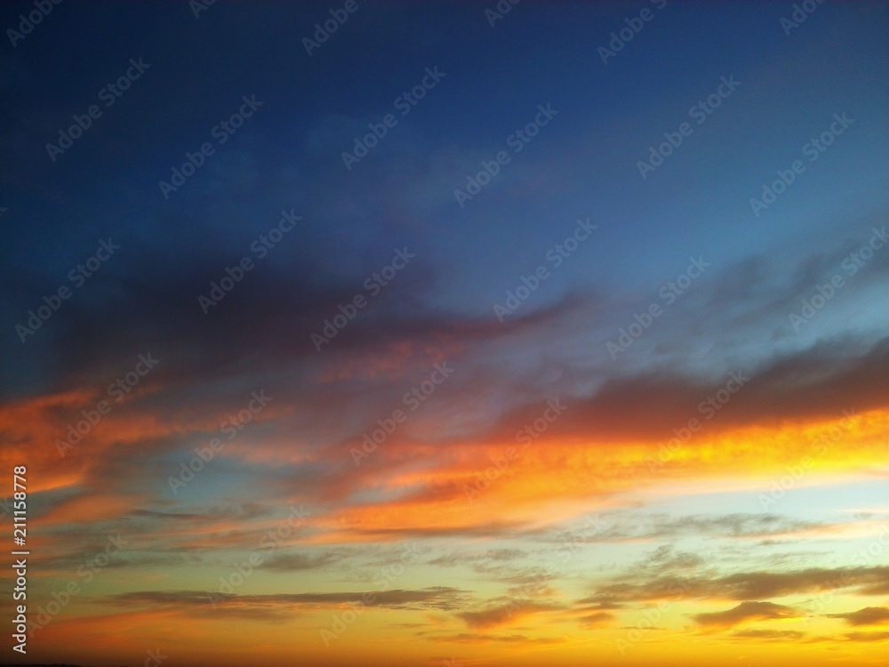 Beautiful sunset with contrast between yellow and the blue sky with clouds