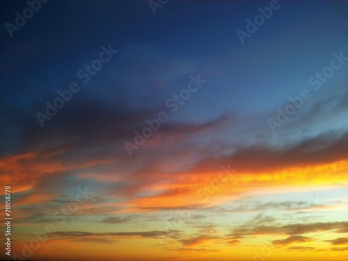 Beautiful sunset with contrast between yellow and the blue sky with clouds