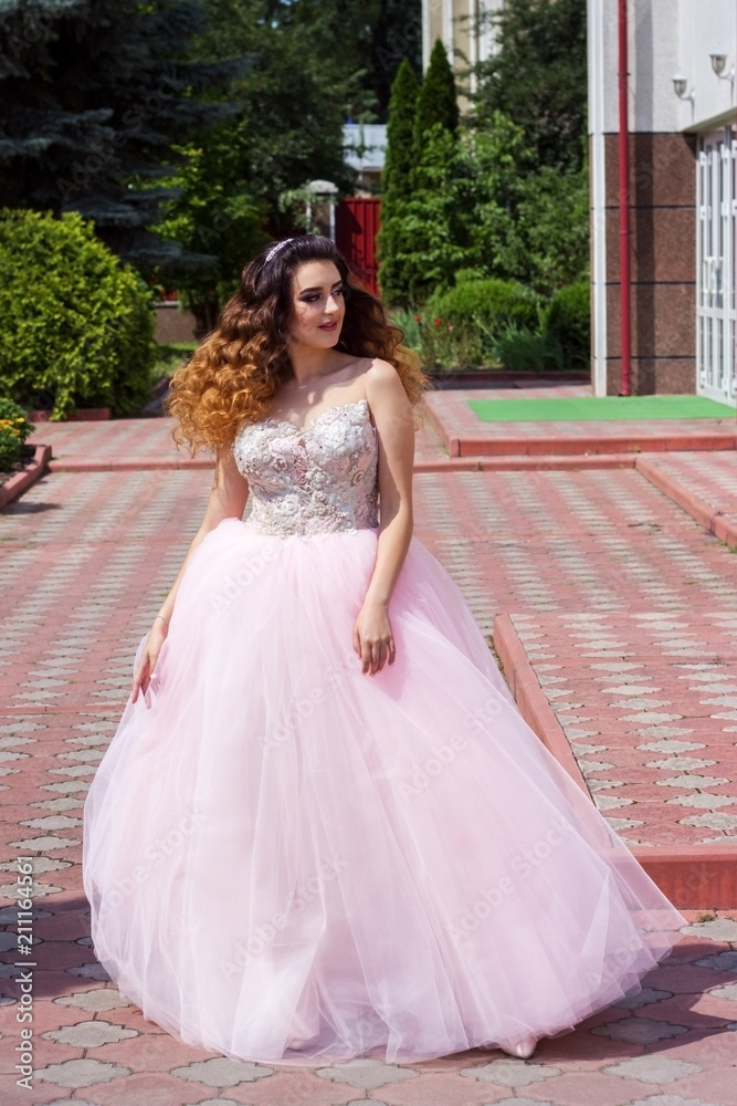 Fototapeta premium Beautiful girl in a lush pink dress