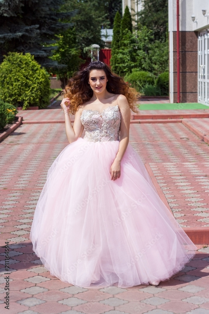 Beautiful girl in a lush pink dress