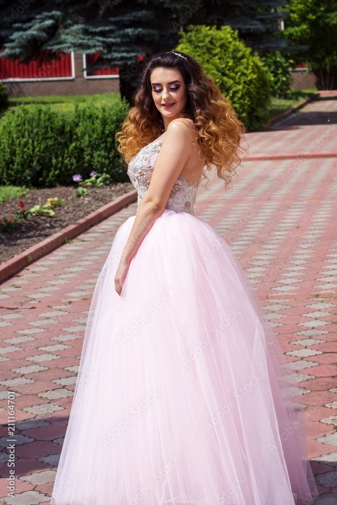 Beautiful girl in a lush pink dress