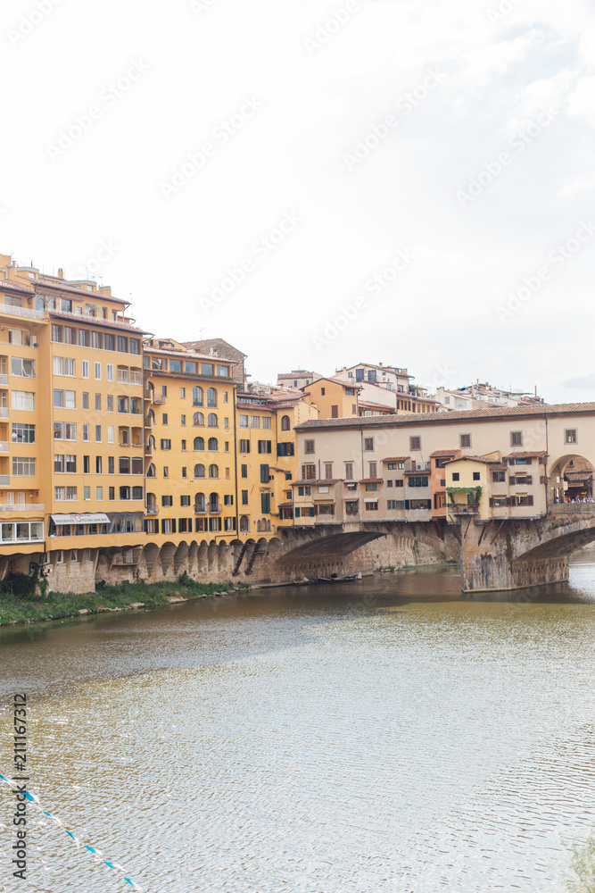view of the Ponte Vecchio bridge on the Arno river in the center of the old city of Florence in Italy