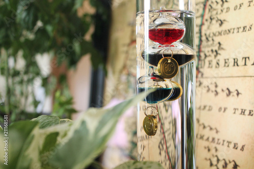 Galileo thermometer with colorful glass bubbles in liquid to tell temperature