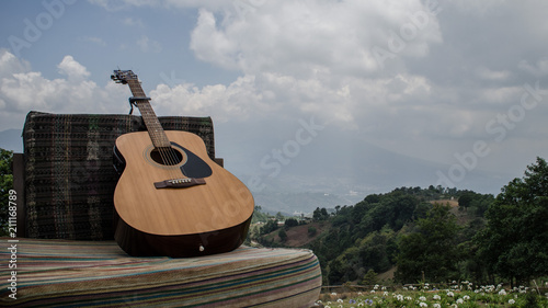 Country guitar laying in front the landscape