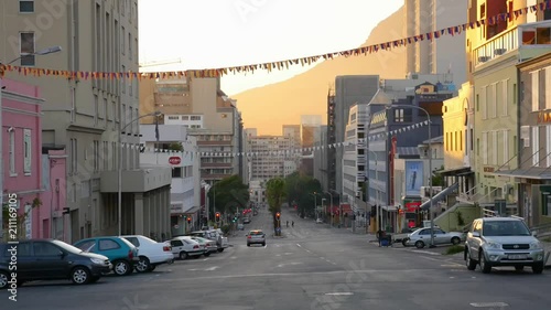 Sunrise in Bo Kaap, Cape Town, South Africa. A single car stands at a red light with the sun rising behind on Devils Peak.