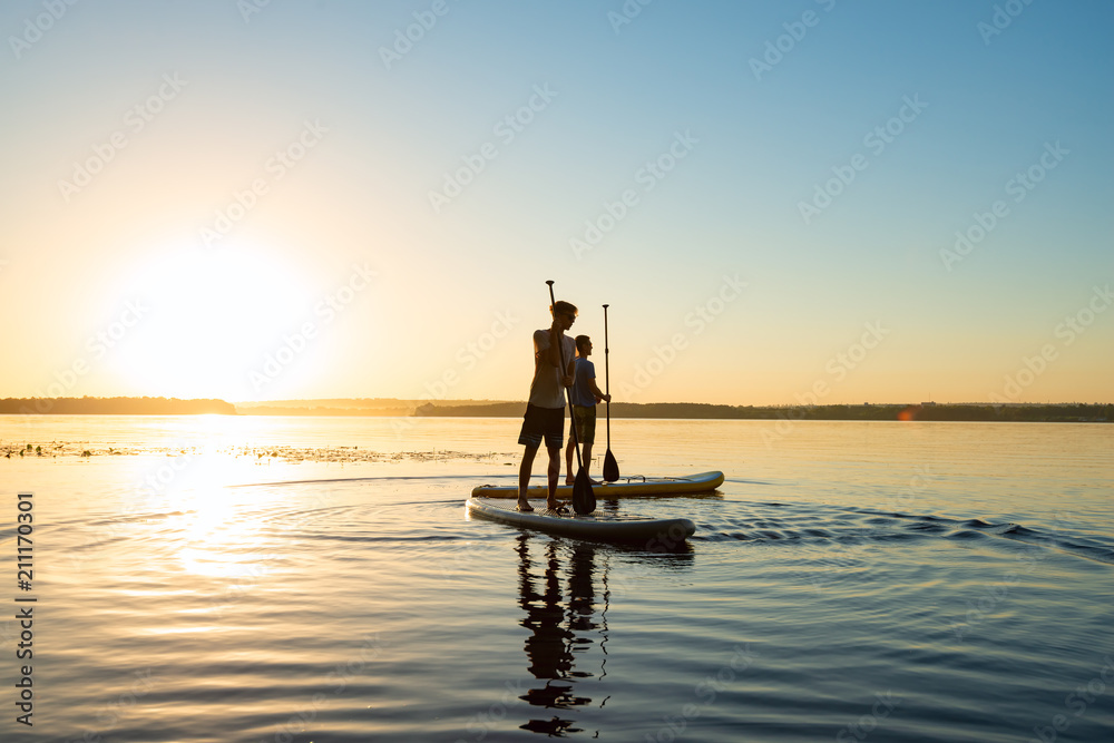 Men, friends relax on a SUP boards