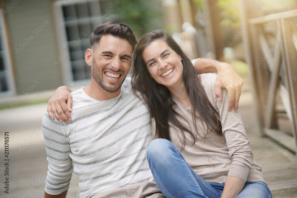 Couple relaxing in yard, embracing each other Couple relaxing in yard, embracing each other