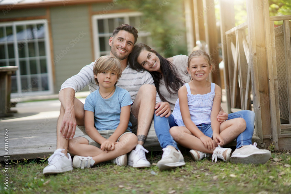 Happy family of four sitting in yard