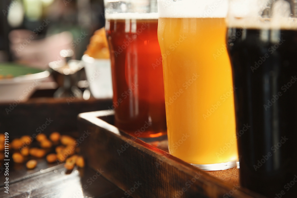 Glasses of tasty beer on wooden table, closeup Glasses of tasty beer on wooden table, closeup