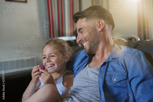 Daddy with little girl watching tv