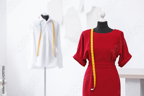 Mannequin with dress and measuring tape in tailor studio photo