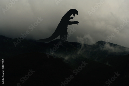 Silhouette eines Godzilla-artigen Monsters im Nebel auf einem Berg
