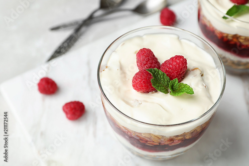 Delicious oatmeal dessert with raspberries in glass on marble board